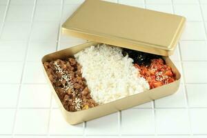 Korean Style Packed Meal with Bulgogi, Kimchi, and Nori Flakes photo