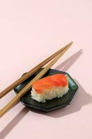 nigiri salmón Sushi en rosado mesa foto