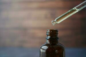 pipette and oil in a small container on table photo