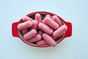 Mini Sausage in a red color bowl on white photo