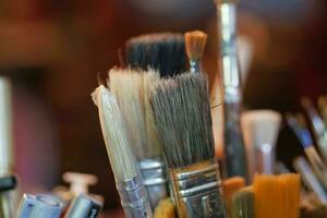 Paints and paint brushes in an artists studio. photo