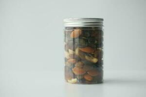 close up of many mixed nuts in a container on white background photo