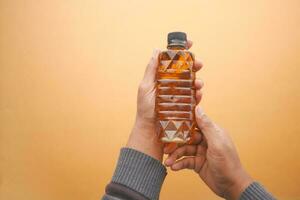 men holding a bottle of oil bottle photo