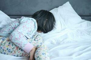 a upset child girl sleeping on bed photo