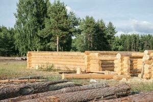 Wooden a log houses under construction with building materials lying nearby photo