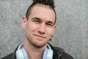 Portrait of a young smiling guy with dreadlocks and piercings photo