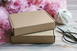 Brown cardboard boxes and peony flowers. Package box for branding. Mock up gift boxes photo