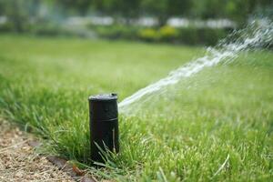 automatic watering grass, garden lawn sprinkler in action. photo