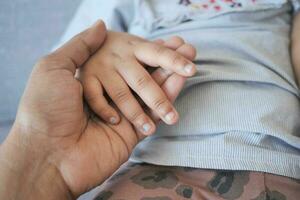 father holding hand of baby child, close up . photo