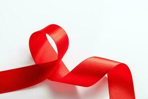 Red silk ribbon for wrapping gifts on white background. photo