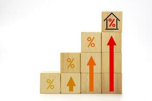 House interest rate with rising percentage and high up arrow icon on wooden blocks cube. Real estate property investment and house loan concept. photo