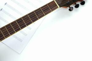 Focus the acoustic guitar neck and blur musical notes on white background. Love, music and learning concept. photo