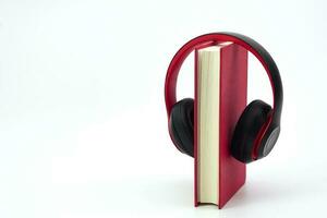 Stack of books with headphones hanging on. Modern education and relaxation concept. photo