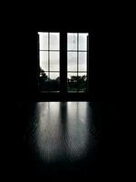 a window lights up a dark room giving a dark horror effect photo