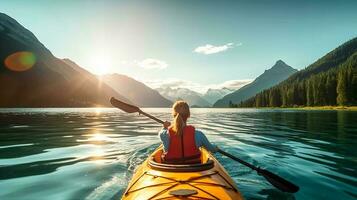 Young woman kayaking on mountain lake. Adventure and sport concept photo