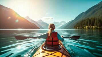 Young woman kayaking on mountain lake. Adventure and sport concept photo