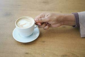 women holding a coffee cup on table photo