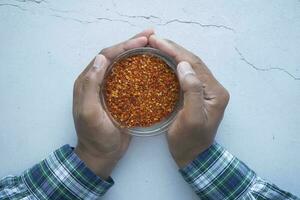 top view of chili flakes in a bowl on table photo