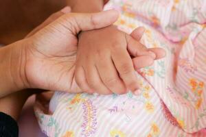 mother holding hand of baby child, close up . photo