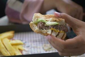 women holding a half eaten burger photo