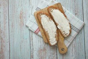 Slice of bread and cream cheese on white background. photo