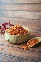 chili flakes in a bowl on table photo