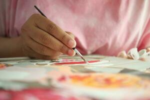 women hand holding brush with paint photo