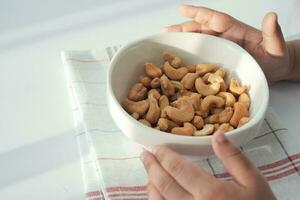 child eating cashew nuts on table photo