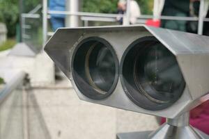 Coin-operated binoculars looking out over city , photo