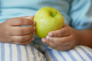 child hand hold a apple closeup photo