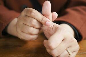 Young women hands suffering pain on thumb finger photo