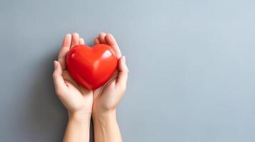 Female hands holding a red heart on a gray background with copy space, Charity Day Concept, Generative AI photo