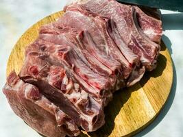 Fresh portioned raw pork ribs steaks on a wooden kitchen board. Pieces of pig meat close-up photo