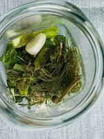 The process of pickling cucumbers for the winter in glass jars. Spices for salting are laid out in jars. photo