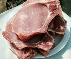 Fresh portioned raw pork ribs steaks on a wooden kitchen board. Pieces of pig meat close-up photo