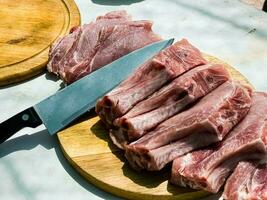 Fresh portioned raw pork ribs steaks on a wooden kitchen board. Pieces of pig meat close-up photo