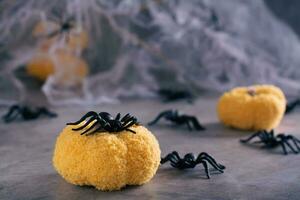 Halloween spider on a handmade knitted pumpkin on a cobweb background photo