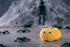 Halloween knitted pumpkin with eyes and spiders on the background of cobwebs photo