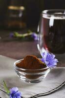 Chicory powder and flower in a bowl for preparing a vitamin drink vertical view photo