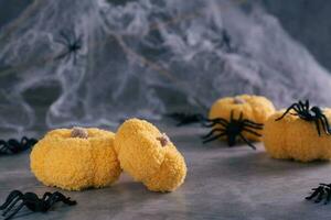 Handmade knitted pumpkins and spiders for Halloween on the background of cobwebs and spiders photo