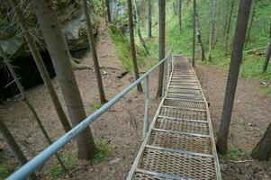 Stainless steel ladder to the cave, Deer Ruchy Nature Park in the Sverdlovsk region, Karstovy Bridge rock. photo