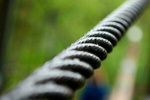 Close up steel cable that connects the suspension bridge on the river. photo