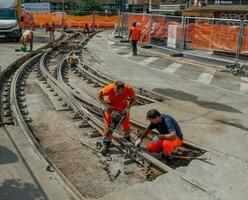 trabajadores a trabajo mientras sistenabo el tranvía rieles foto