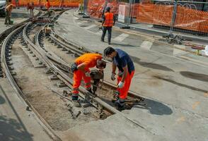 Workers at work while sistenabo the tram rails photo