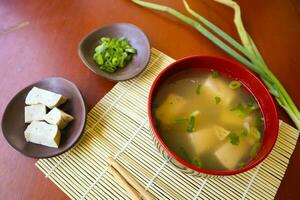 miso soup or Japanese miso soup in bowl on the table. Japanese cuisine in the form of soup with dashi ingredients, tofu, seafood, vegetables, and topped with miso to taste photo