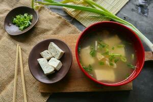 miso soup or Japanese miso soup in bowl on the table. Japanese cuisine in the form of soup with dashi ingredients, tofu, seafood, vegetables, and topped with miso to taste photo