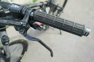 Bike front gear switch, brake lever and grip on handlebar on mountain bike. photo