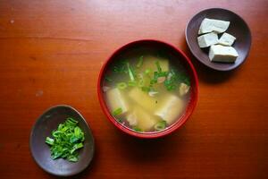 miso soup or Japanese miso soup in bowl on the table. Japanese cuisine in the form of soup with dashi ingredients, tofu, seafood, vegetables, and topped with miso to taste photo