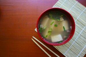 miso soup or Japanese miso soup in bowl on the table. Japanese cuisine in the form of soup with dashi ingredients, tofu, seafood, vegetables, and topped with miso to taste photo