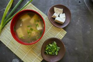 miso soup or Japanese miso soup in bowl on the table. Japanese cuisine in the form of soup with dashi ingredients, tofu, seafood, vegetables, and topped with miso to taste photo